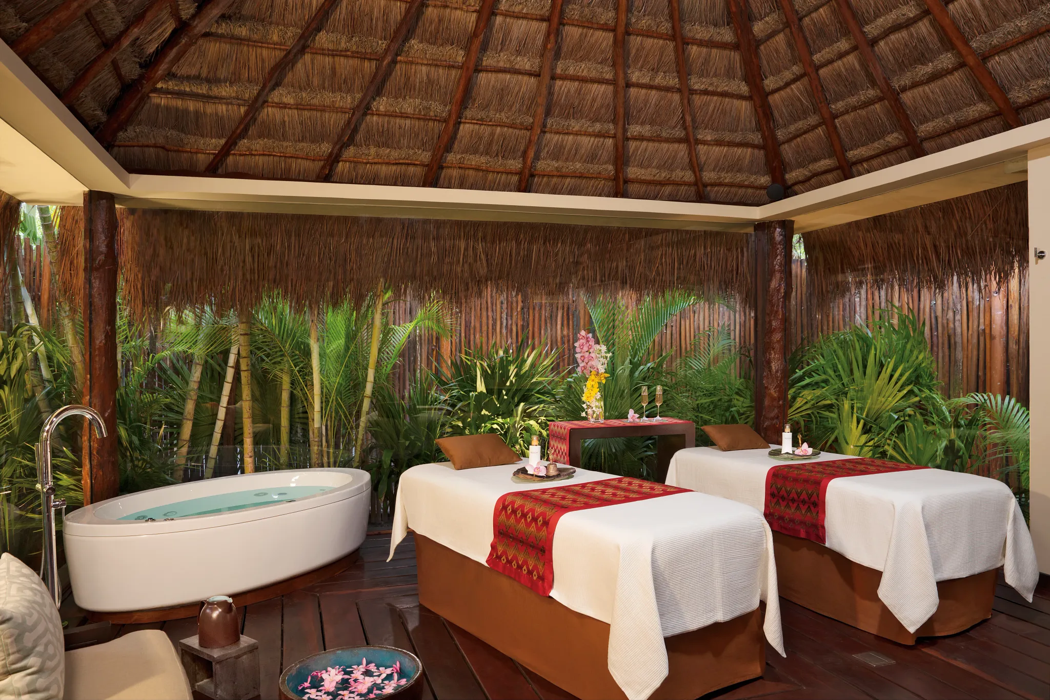Spa treatment room with dual massage beds and jacuzzi tub at Dreams Riviera Cancun Resort & Spa.