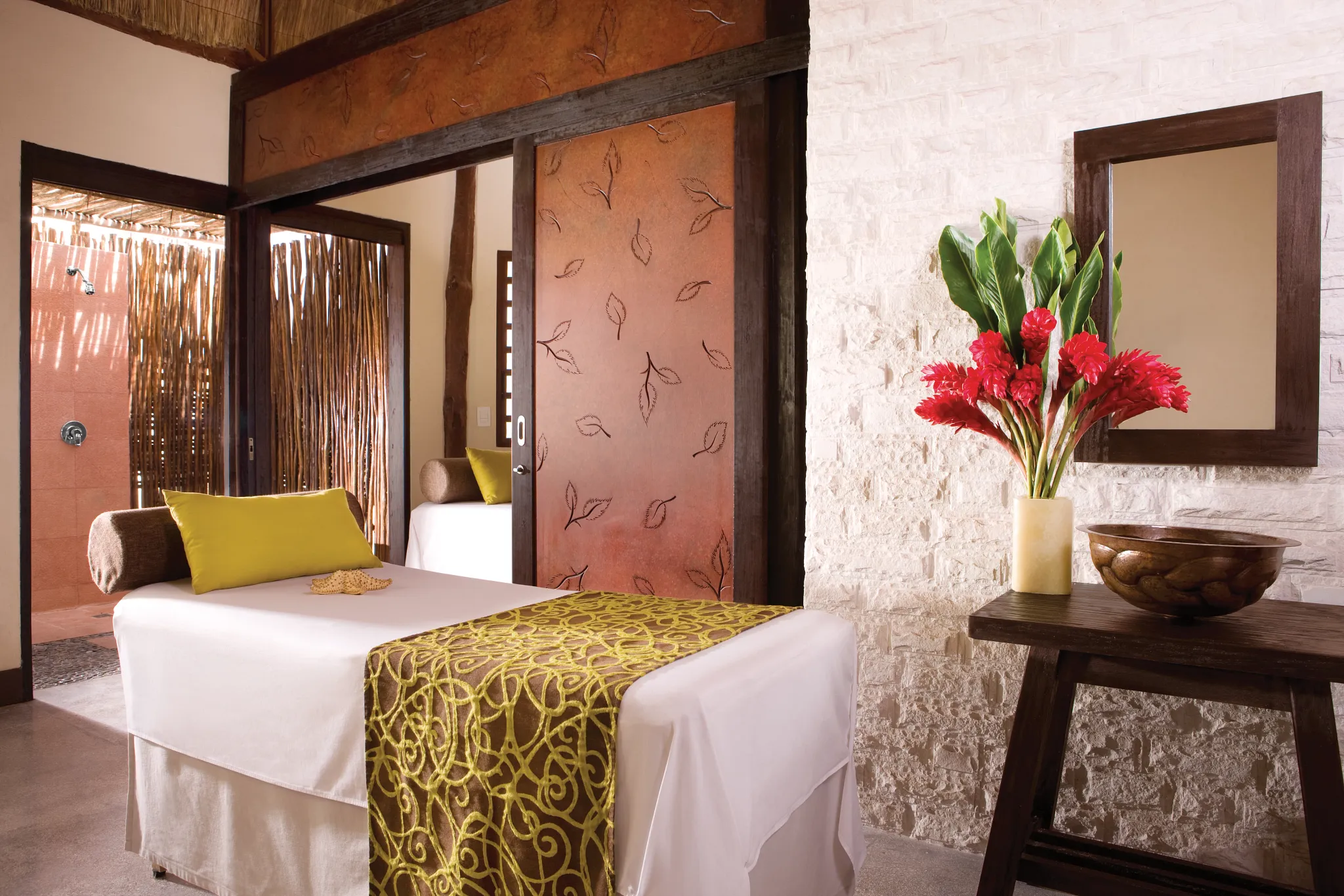 Private spa cabin with massage table and tropical décor at Dreams Riviera Cancun Resort & Spa.