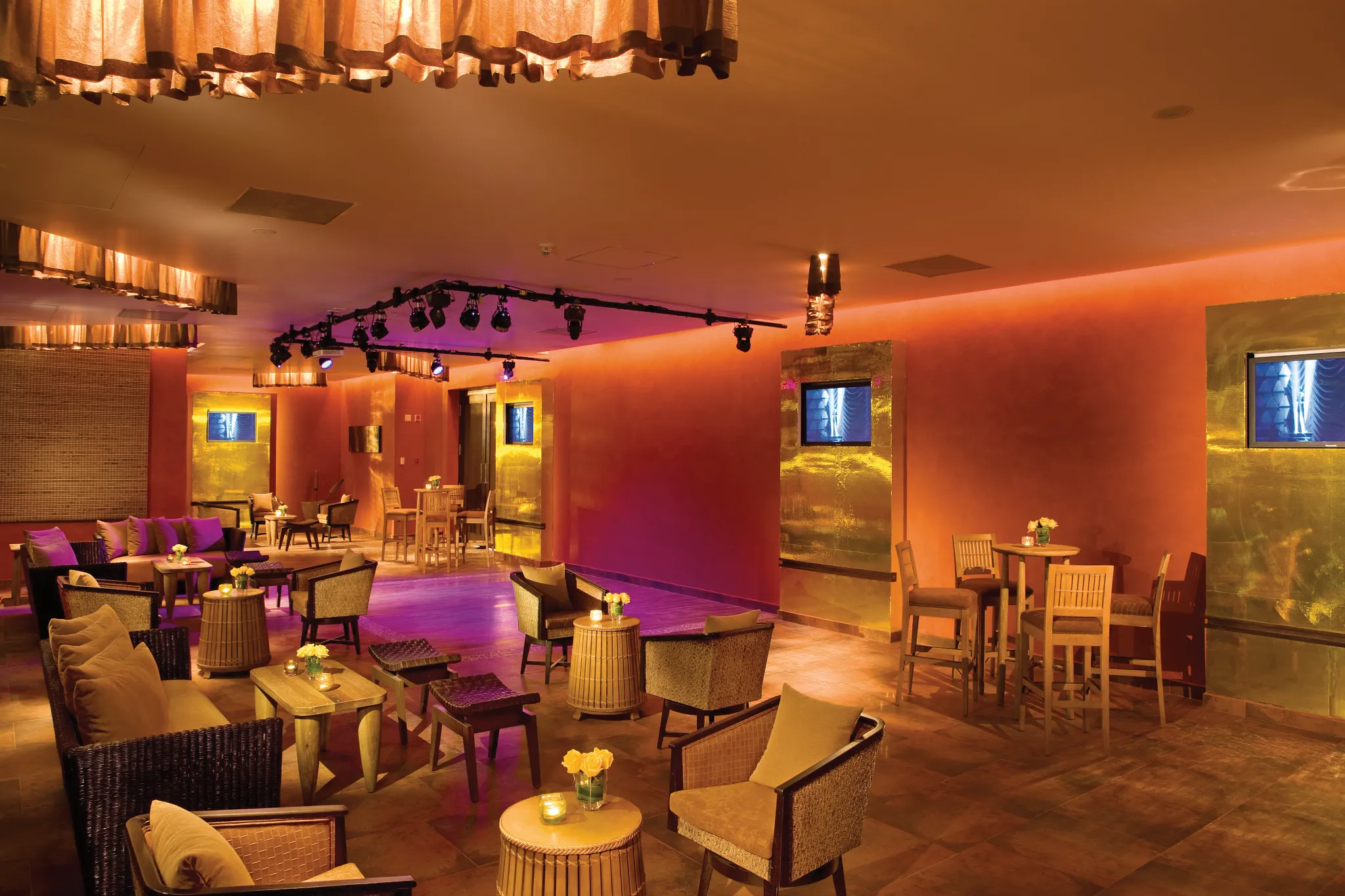 Desires Sports and Music Lounge at Dreams Riviera Cancun Resort & Spa featuring modern bar seating, outdoor terraces, and lively nighttime entertainment.