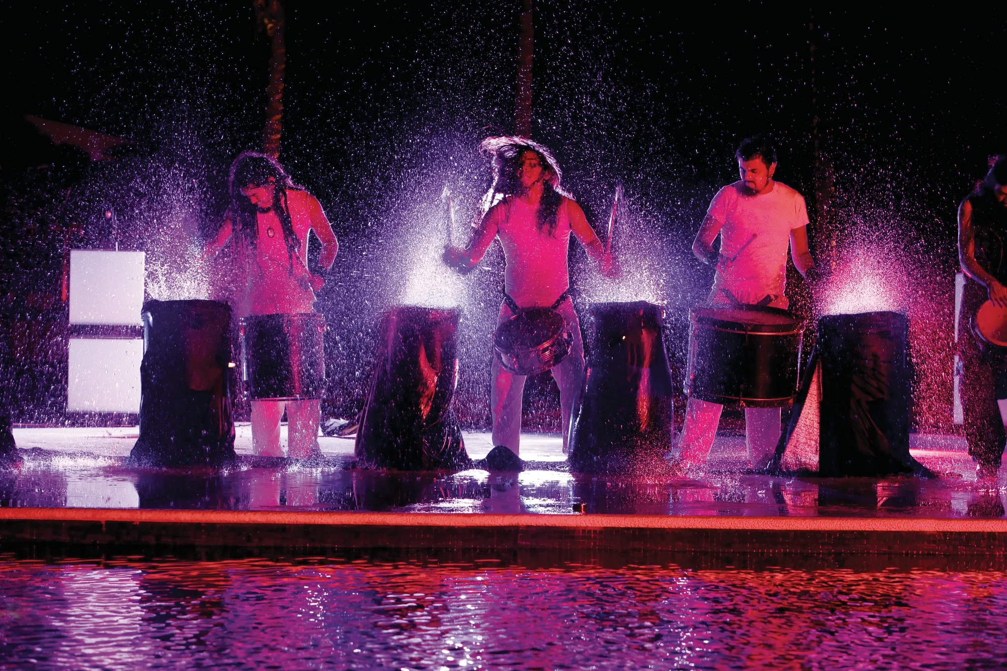 Live drum performance with water effects and colorful lighting at Dreams Riviera Cancun Resort & Spa.