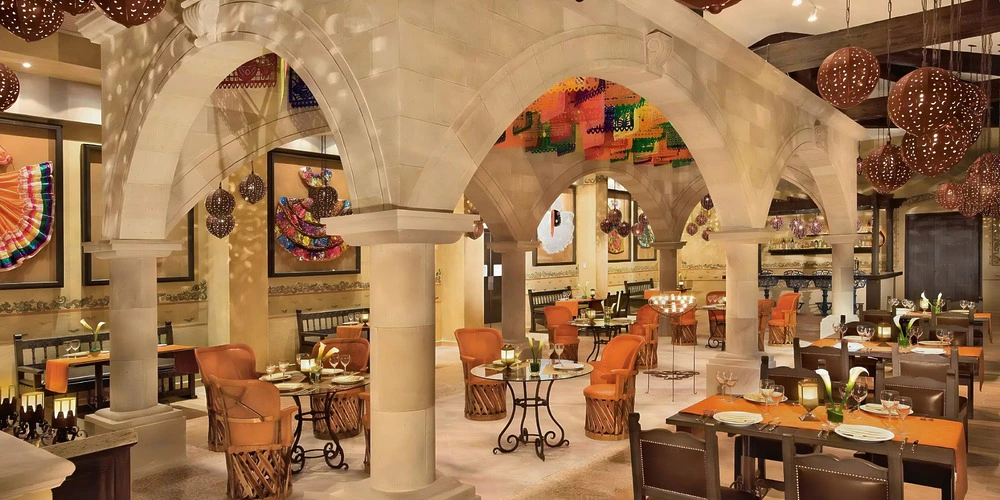 El Patio restaurant indoor reception setup with arches and warm décor at Dreams Riviera Cancun