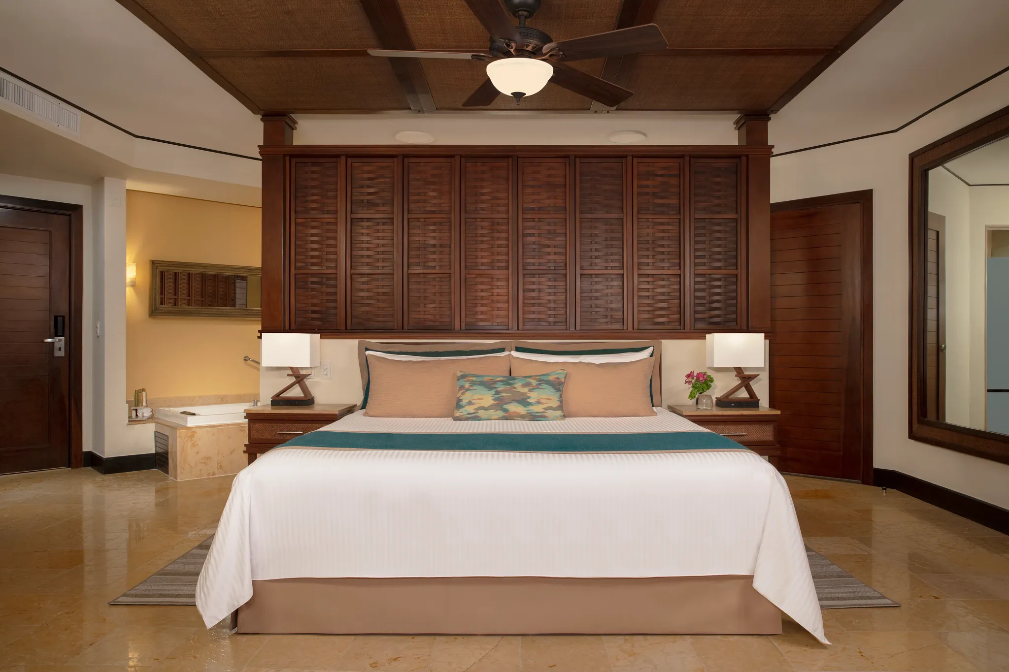 Family Suite Preferred with king bed, wood-paneled headboard, and indoor hot tub at Dreams Riviera Cancun Resort & Spa.