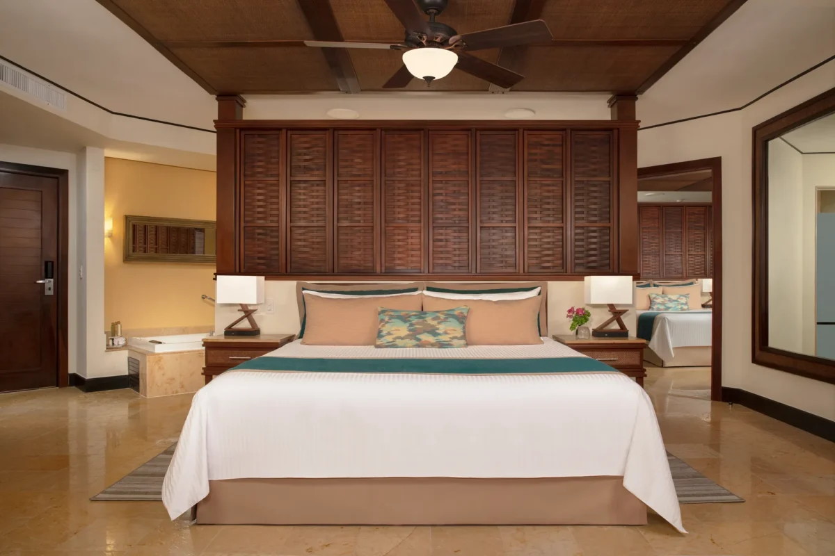 Family Suite Premium king bedroom with tropical décor at Dreams Riviera Cancun Resort & Spa.