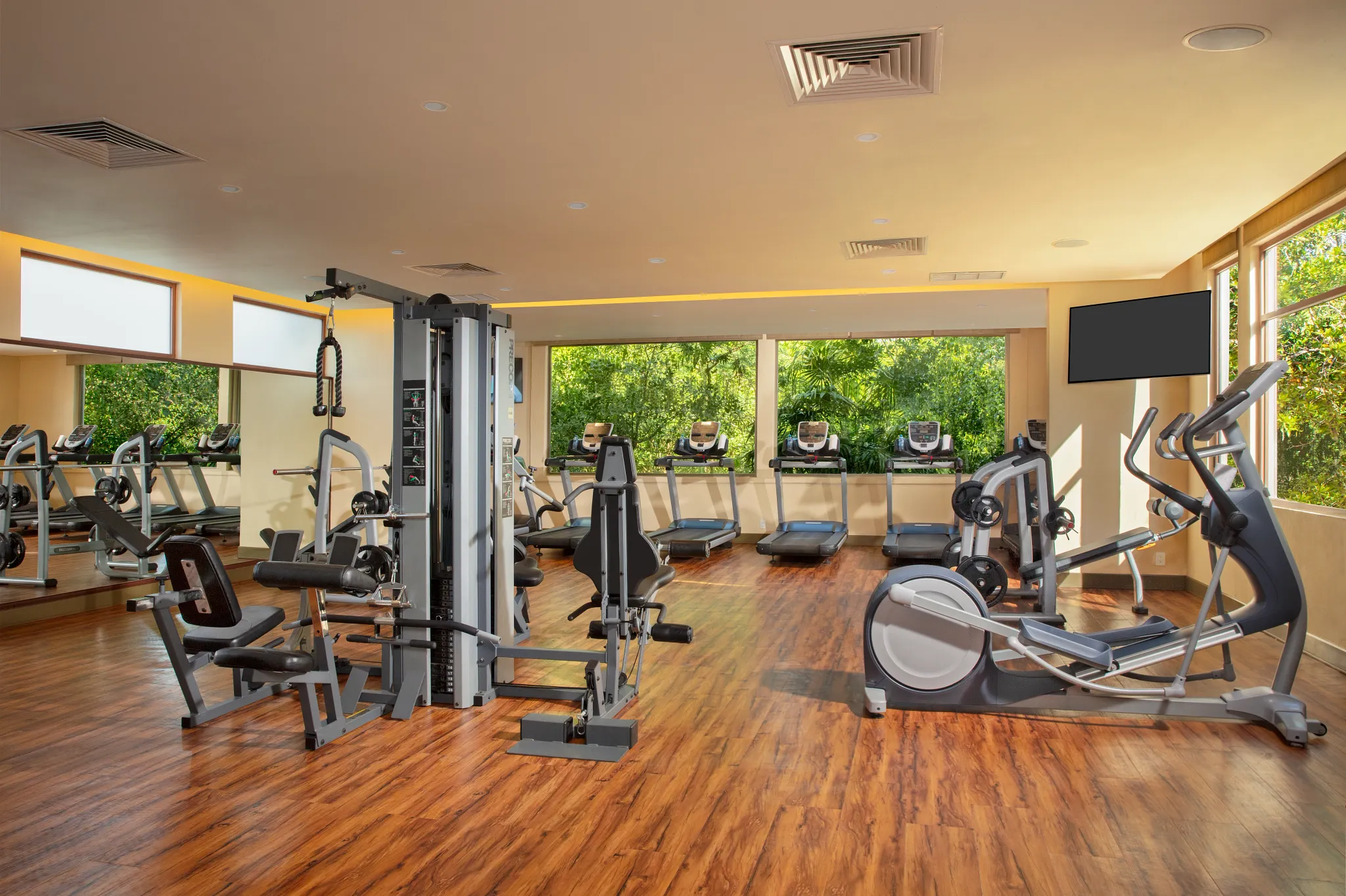 Modern fitness center with cardio machines and weights at Dreams Riviera Cancun Resort & Spa.