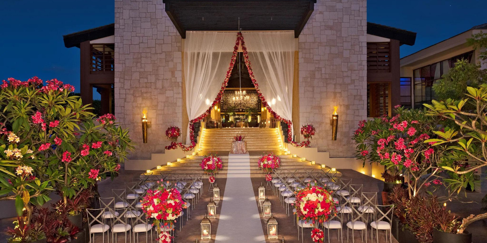 Grand lobby staircase wedding ceremony setup with floral décor at Dreams Riviera Cancun