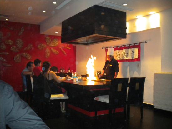 Himitsu Pan-Asian restaurant at Dreams Riviera Cancun featuring a teppanyaki grill experience with chef cooking tableside and modern Asian-inspired decor.