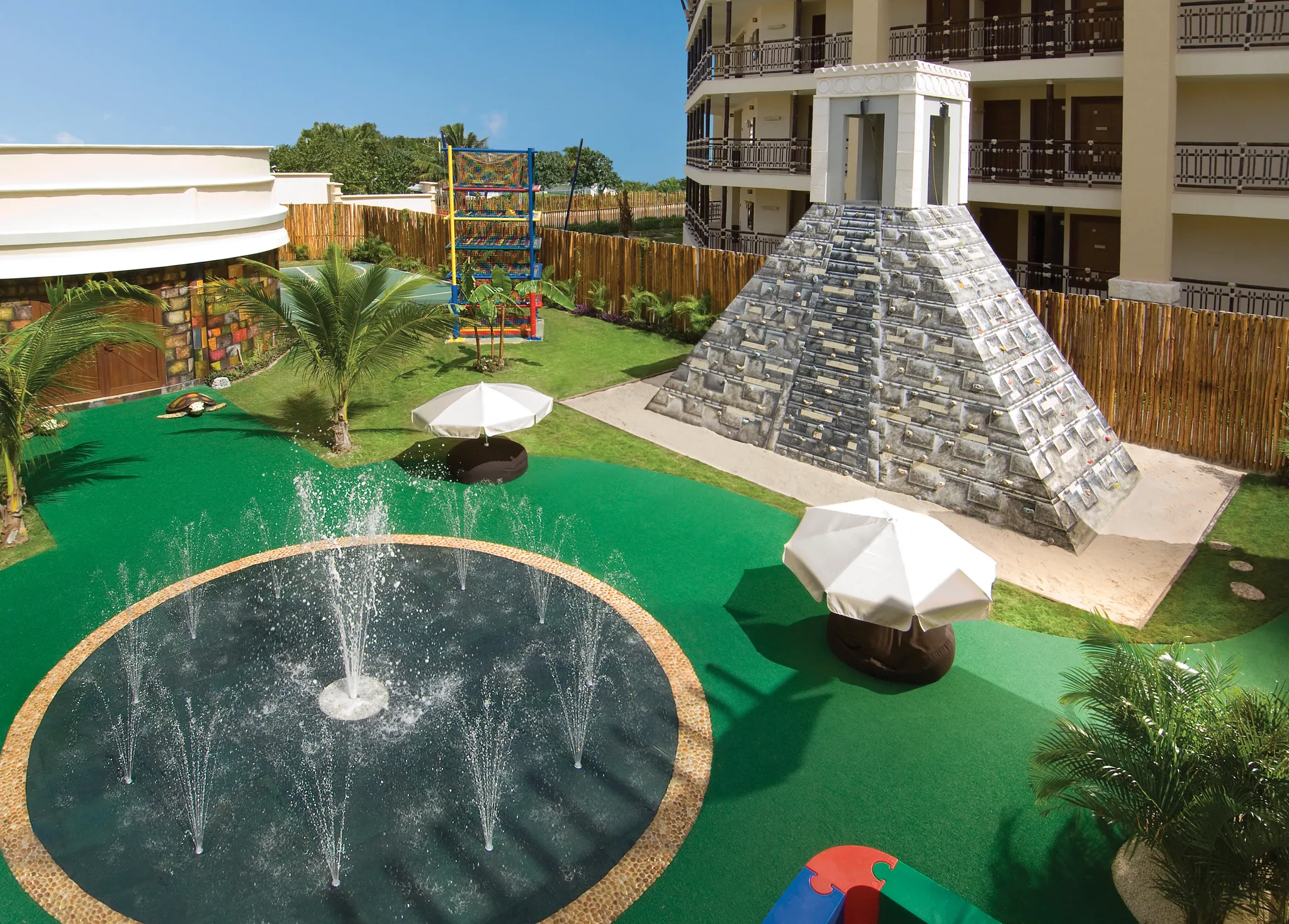 Outdoor kids splash park and climbing pyramid at Dreams Riviera Cancun Resort & Spa family area.