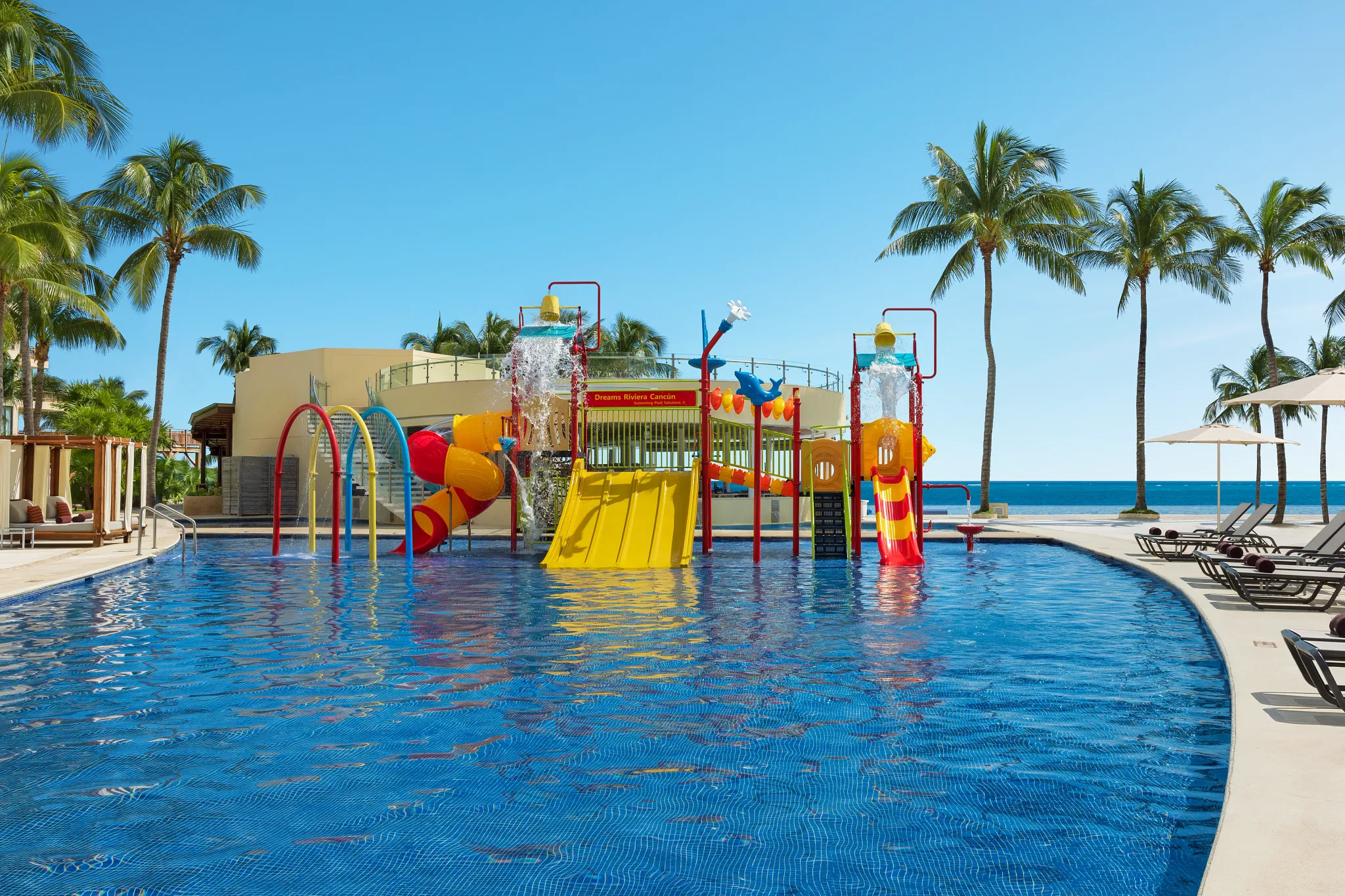 Colorful kids water park with slides and splash features at Dreams Riviera Cancun Resort & Spa.