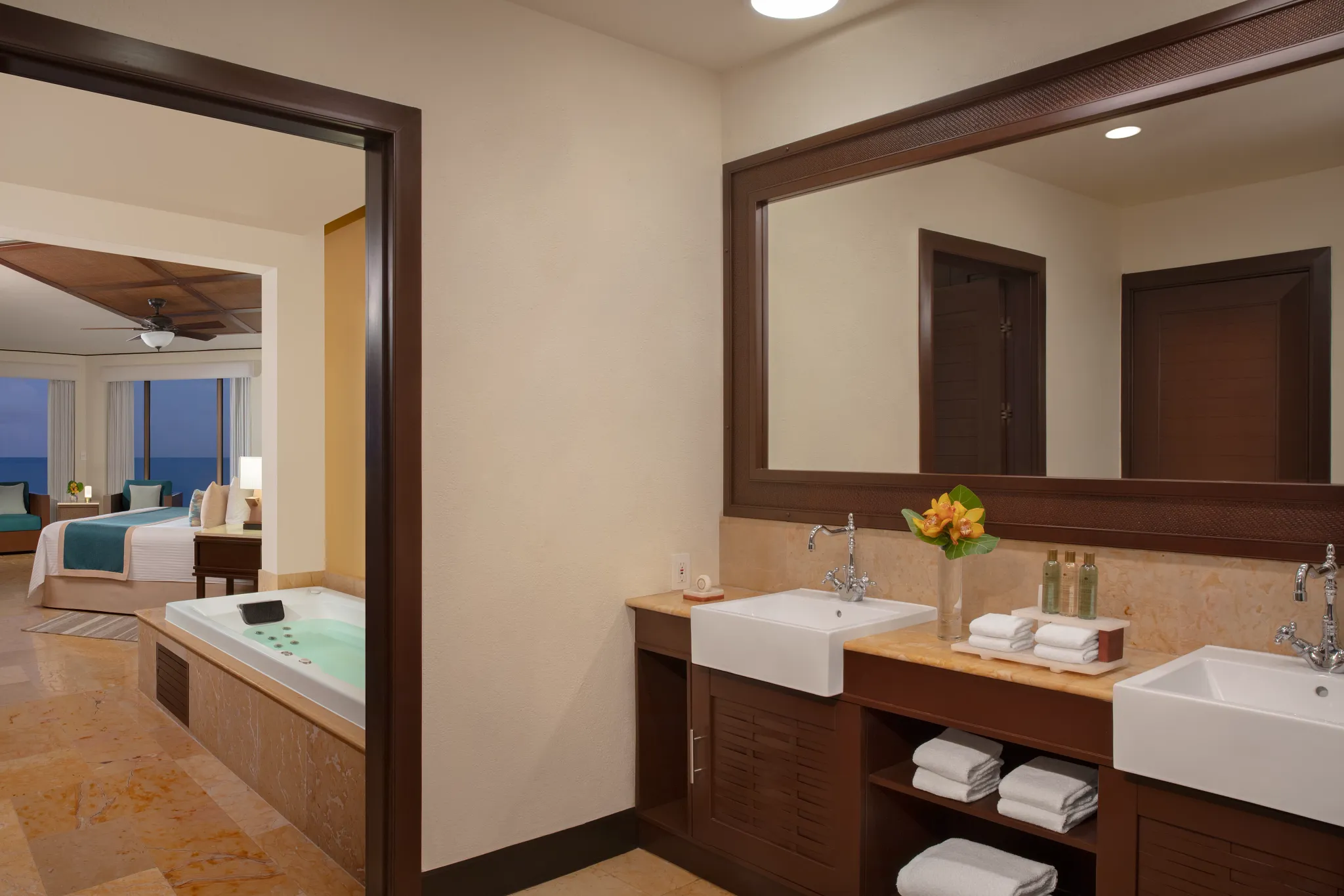 Preferred Club Ocean Front Master Suite bathroom with double sinks and indoor hot tub at Dreams Riviera Cancun Resort & Spa.