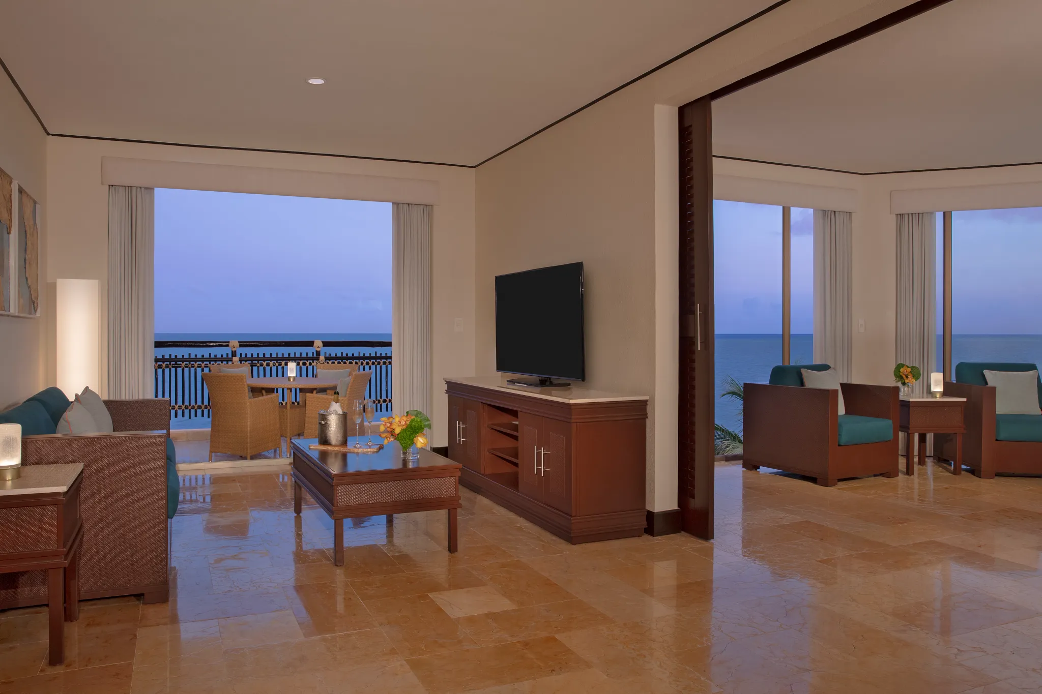 Preferred Club Ocean Front Master Suite living area with sofa and ocean view balcony at Dreams Riviera Cancun Resort & Spa.