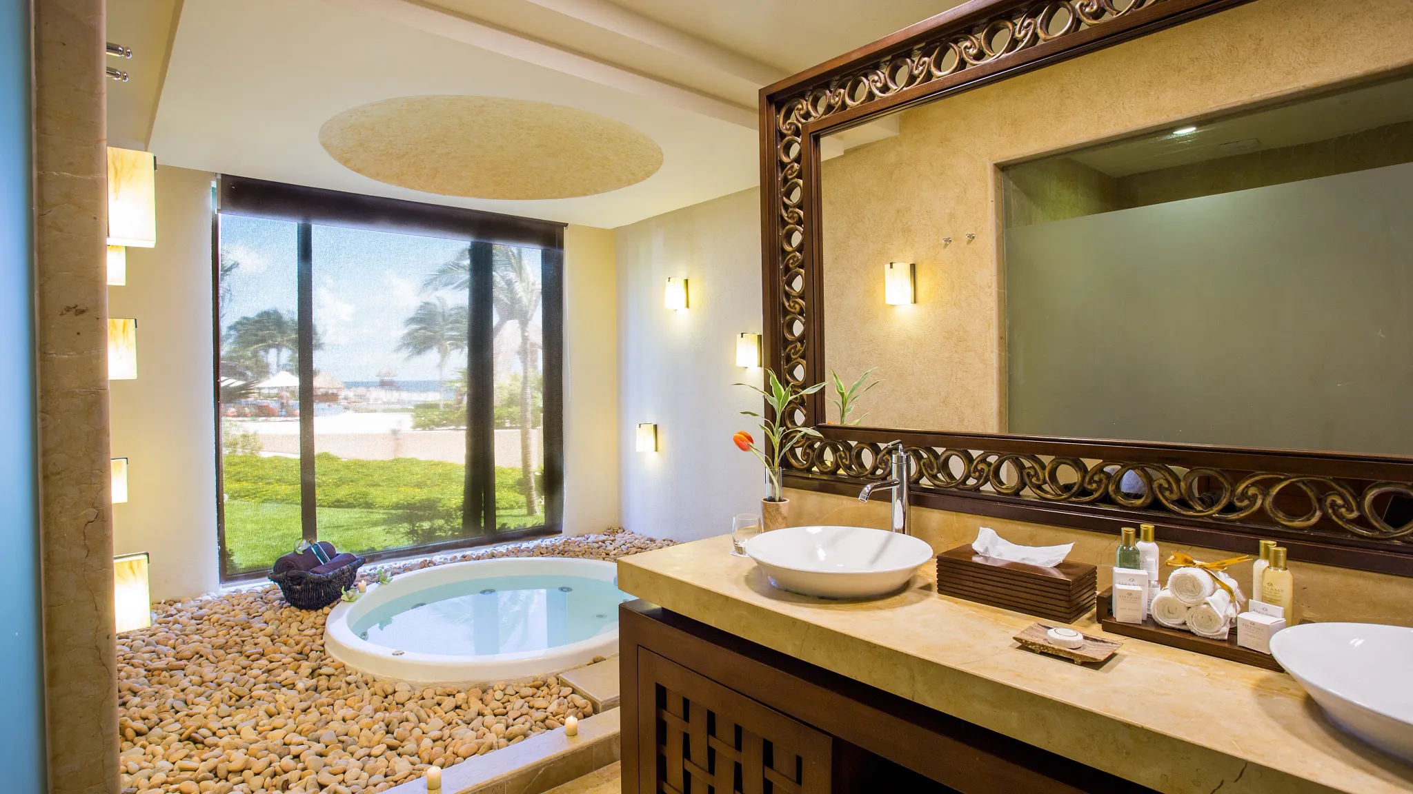 Preferred Club Ocean Front Presidential Suite bathroom with dual sinks and indoor hot tub near window at Dreams Riviera Cancun Resort & Spa.
