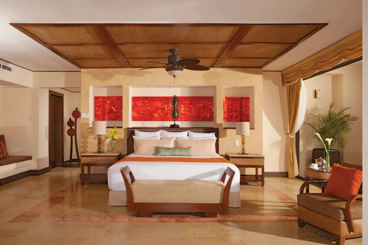 Preferred Club Ocean Front Presidential Suite bedroom with king bed and oceanfront style décor at Dreams Riviera Cancun Resort & Spa.