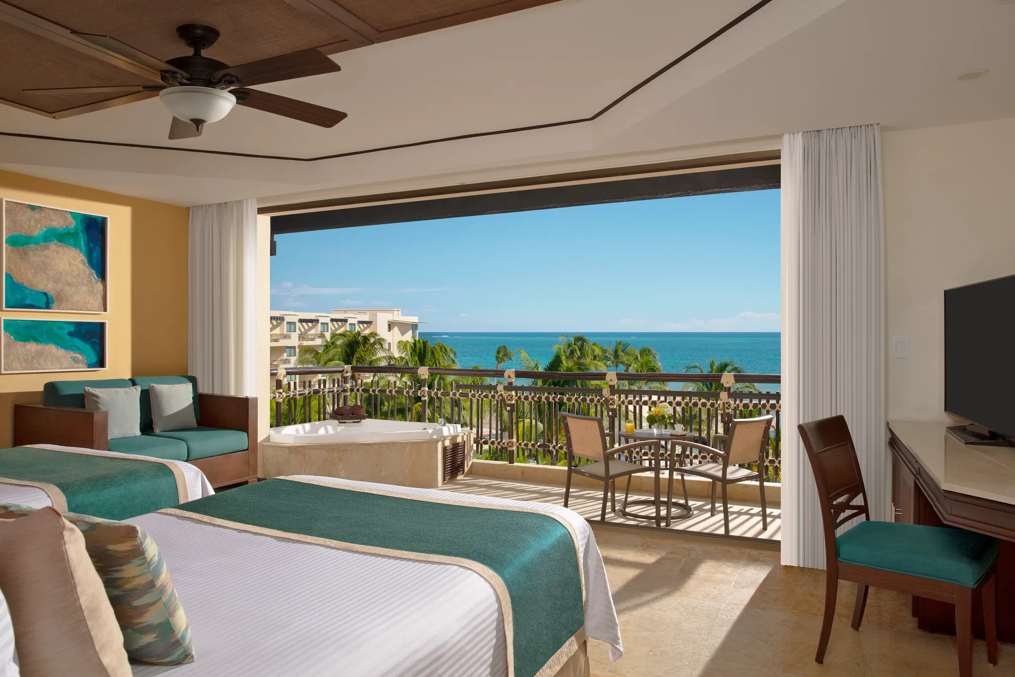 Preferred Club Ocean View & Pool Front room with two double beds and balcony overlooking ocean and pool at Dreams Riviera Cancun.